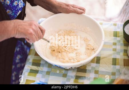 Grand-mère préparant de la pâte pour des crêpes Banque D'Images