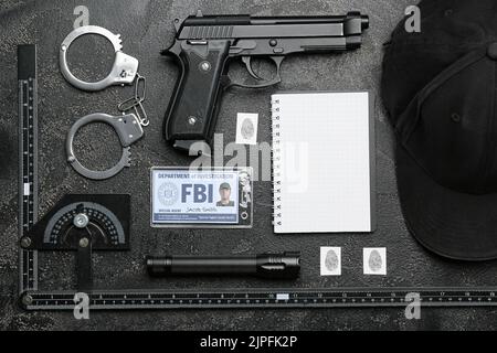 Ordinateur portable avec document de l'agent FBI et accessoires sur fond sombre Banque D'Images