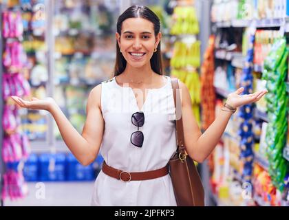 Shopping, vente au détail et consumérisme avec une cliente qui se trouve dans une épicerie, un magasin ou un supermarché. Portrait d'une jeune femme en gestuelle Banque D'Images