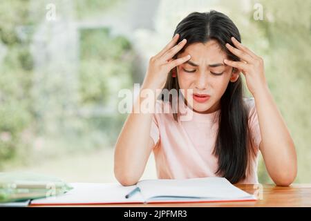 Stress, anxiété et inquiétude avec une petite fille qui lutte avec ses études, l'éducation et l'apprentissage à la maison. Étudiant confus, frustré et contrarié Banque D'Images