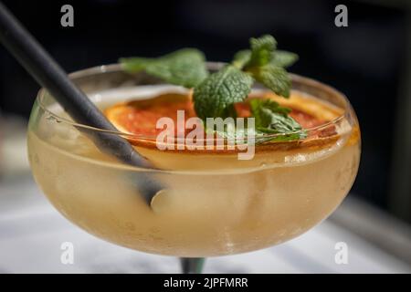 Cocktail avec garniture à la menthe et à l'orange séchées et bol d'en-cas de bar Banque D'Images