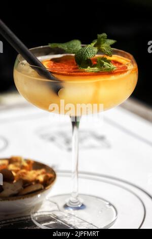 Cocktail avec garniture à la menthe et à l'orange séchées et bol d'en-cas de bar Banque D'Images