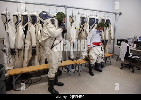 Kennedy Space Center, Floride, États-Unis. 16th août 2019. Le 16 août 2019, les techniciens ont mis des combinaisons de protection atmosphérique autonomes (SCAPE) à l'intérieur d'un vestiaires dans le bâtiment de soutien multi-opérations près de l'installation de traitement multi-charge utile (MPPF) du Kennedy Space Center de la NASA en Floride. Les techniciens DE SCAPE s'exercent en mettant sur les costumes pour une simulation d'essai de chargement de propulseurs dans un banc d'essai répliqué pour Orion. Exploration Ground Systems se prépare pour Artemis 1 avec une série d'épreuves d'hyper-test dangereuses au MPPF. Après avoir donné leurs costumes, le technique Banque D'Images