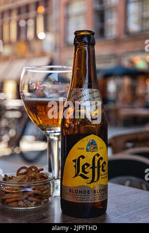 BRUGES, BELGIQUE - 11 AOÛT 2022 : bouteille de bière Leffe Bonde avec verre brasserie sur une table dans le centre-ville Banque D'Images