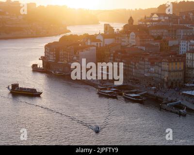 Vue imprenable sur le quartier riverain de Ribeira et le fleuve Douro à Porto, Portugal. Le bateau avec les passagers arrive dans le port. Banque D'Images