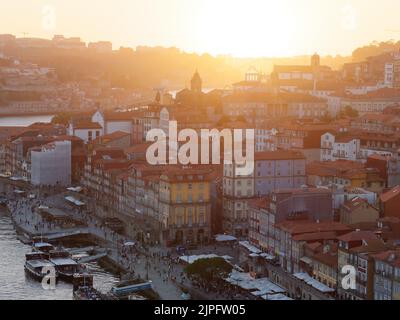 Vue imprenable sur le quartier riverain de Ribeira et le fleuve Douro à Porto, Portugal. Les bateaux sont amarrés dans le port. Banque D'Images