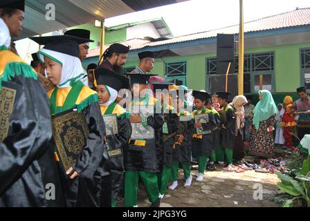 Tegal (INDONÉSIE), le 3 mai 2018 - les élèves de la maternelle musulmane paient leurs derniers respects aux enseignants en les embrassant à la fin de leur diplôme Banque D'Images