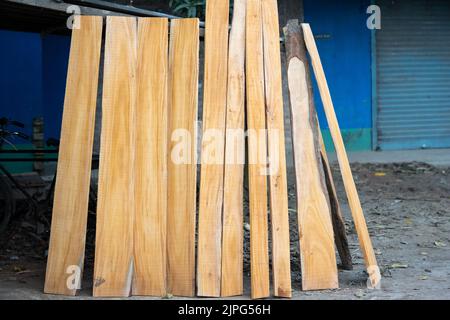 Bois d'eucalyptus avec arrière-plan flou. Les planches en bois sont stockées pour la fabrication de meubles en bois. Mise au point sélective, espace de copie. Banque D'Images