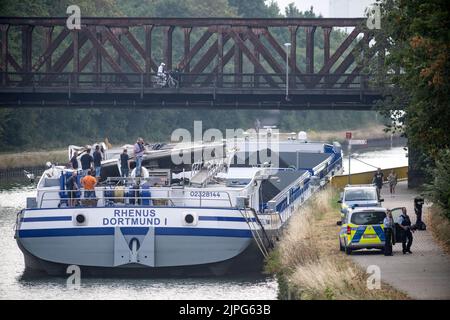 Dorsten, Allemagne. 18th août 2022. Les enquêteurs de la police des eaux sont debout sur un navire dont le taxi du conducteur est bosselé, sur le canal Wesel-Datteln. Le convoi poussé s'était écrasé sur un pont routier de Dorsten. Le skipper de 42 ans a été blessé et hospitalisé. Le taxi du navire et le pont ont été endommagés au cours de l'incident. Le pont a été fermé à la circulation routière entre-temps. Un pont ferroviaire peut être vu en arrière-plan, ce qui n'était pas le lieu de l'accident. Credit: Bernd Thissen/dpa/Alay Live News Banque D'Images