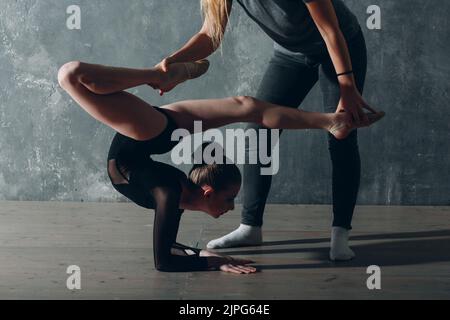 Jeune fille gymnaste professionnelle avec entraîneur femme danse gymnastique rythmique au studio. Banque D'Images