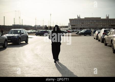 Un homme marche dans le parking. Homme en ville. Guy dans la place. Descendez la rue. Banque D'Images