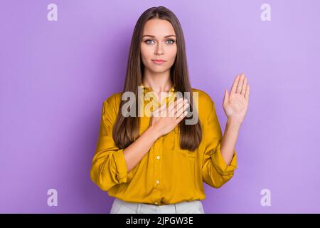 Photo de femme millénaire sérieuse priez porter une chemise jaune isolée sur fond violet Banque D'Images