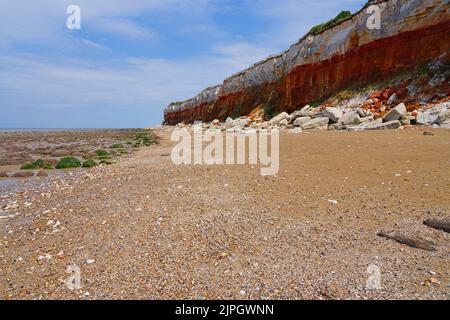 Rock tombe le long de la plage depuis les falaises érodantes de Hunstanton sur la côte de Norfolk. Banque D'Images