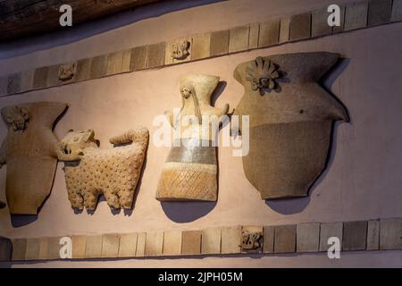 Des figures de céramique de style autochtone préhispanique décorent le mur d'un restaurant à San Pedro de Atacama dans le nord du Chili. Banque D'Images