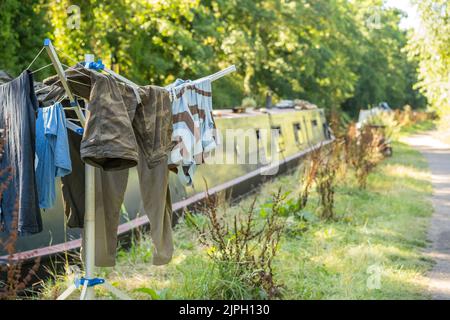 Bateau sur le canal britannique amarré le long du chemin de halage Worcestershire avec des vêtements accrochés au séchage sur la ligne de lavage rotatif portable le jour chaud d'été. Banque D'Images