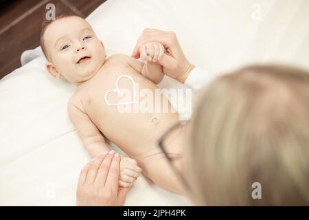 Femme masseuse massant bébé pour pied petit bébé enfant Banque D'Images