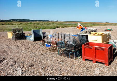 Matériel de pêche entreposé au-dessus de la marque de haute eau sur la plage de galets sur la côte nord de Norfolk à CLEY-Next-the-Sea, Norfolk, Angleterre, Royaume-Uni. Banque D'Images