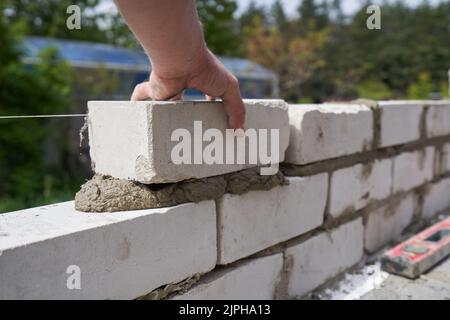 Builder Bricklayer construit des murs à partir de briques, gros plan Banque D'Images