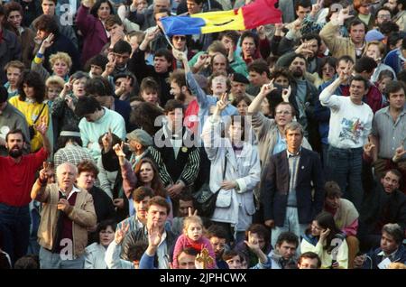 Bucarest, Roumanie, avril 1990. « Golaniada », une importante manifestation anti-communiste sur la place de l'université après la révolution roumaine de 1989. Les gens se rassembleraient tous les jours pour protester contre les ex-communistes qui ont pris le pouvoir après la Révolution. La principale demande était qu'aucun ancien membre du parti ne soit autorisé à se présenter aux élections de 20 mai. Le drapeau roumain avec l'emblème socialiste coupé était un symbole anticommuniste pendant la révolution. Banque D'Images