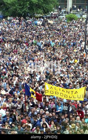 Bucarest, Roumanie, avril 1990. « Golaniada », une importante manifestation anti-communiste sur la place de l'université après la révolution roumaine de 1989. Les gens se rassembleraient tous les jours pour protester contre les ex-communistes qui ont pris le pouvoir après la Révolution. La principale demande était qu'aucun ancien membre du parti ne soit autorisé à se présenter aux élections de 20 mai. La bannière dit « l'alliance du peuple ». Le drapeau roumain avec l'emblème socialiste coupé était un symbole anticommuniste pendant la révolution. Banque D'Images