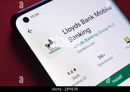 Application bancaire lloyds vue dans Google Play Store sur l'écran du smartphone placé sur fond rouge. Gros plan avec mise au point sélective. Stafford, États-Unis Banque D'Images