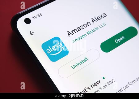 l'application alexa d'amazon est visible dans Google Play Store sur l'écran du smartphone placé sur fond rouge. Gros plan avec mise au point sélective. Stafford, United Ki Banque D'Images