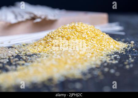 Grains de maïs finement broyés en flocons pour faire du porridge, maïs broyé pour faire un petit déjeuner rapide Banque D'Images