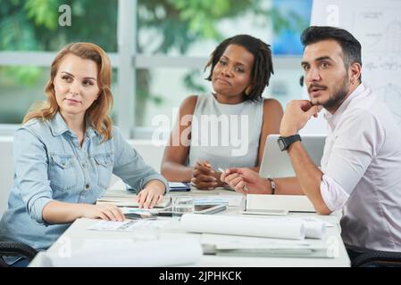 Une équipe pluriethnique composée de cols blancs qui s'intéressent à la salle de réunion spacieuse tout en participant à des présentations professionnelles Banque D'Images
