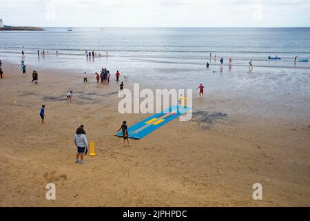 Séances d'entraînement de cricket pour les jeunes garçons asiatiques sur la plage de Scarborough à marée basse Banque D'Images