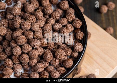 les boules de chocolat sont utilisées comme un petit déjeuner sec avec l'ajout de lait ou de yaourt, boules de chocolat pour la cuisson rapide avec des produits laitiers Banque D'Images