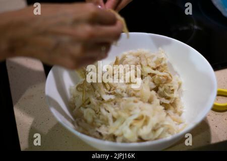 Bacalhau esfiado, cuisine portugaise traditionnelle. Préparation Pazéis de bacalhau ou bolinhos de bacalhau. Banque D'Images