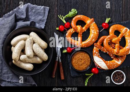 Weisswurst traditionnel dans un bol noir, saucisses blanches de veau haché, bacon de porc, épices et persil, servi avec de la moutarde douce, des bretzels doux, fr Banque D'Images