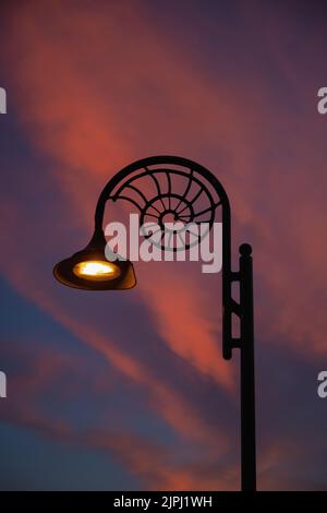 Lampadaire en forme d'ammonite à Lyme Regis, Dorset contre les nuages à l'aube Banque D'Images