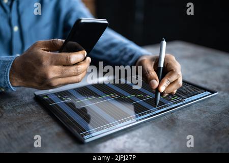 Homme d'affaires travaillant avec le diagramme de Gantt sur ordinateur portable au-dessus du bureau Banque D'Images