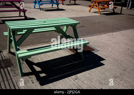 Bancs de pique-nique colorés sur une place du marché par une journée ensoleillée Banque D'Images