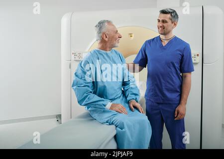 Radiologue parlant avec un patient masculin dans le service de radiologie de l'hôpital avant d'effectuer l'acquisition CT. Tomodensitométrie Banque D'Images