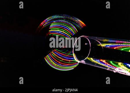 lumières colorées reflétées dans la bulle de savon créée à travers un tube transparent Banque D'Images