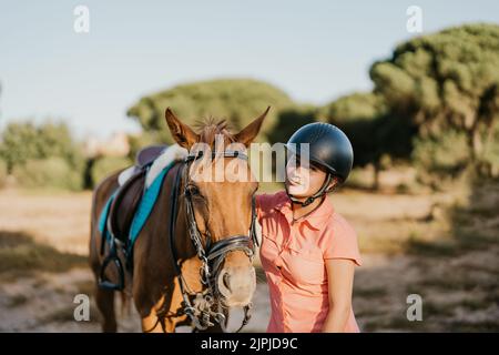 portrait d'une jeune fille aux yeux verts debout à côté de son poney Banque D'Images