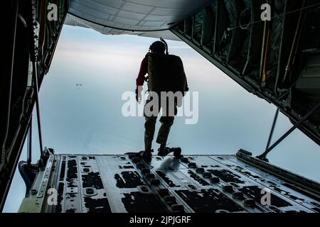 Un parasecouriste affecté à l'escadron de sauvetage 38th saute de l'arrière d'un C-130J Super Hercules pour une opération de récupération du personnel au-dessus de l'eau durant l'exercice Pacific Angel, près de la base aérienne de Kuantan, en Malaisie, le 17 août 2022. L'objectif était de parvenir à un bateau de la méthode alternative de Rigging, ou RAMB, qui est un bateau de raiding en caoutchouc de combat dégonflé qui peut être déposé par parachute dans l'eau et gonflé à l'atterrissage. (É.-U. Photo de la Force aérienne par le premier Airman Jessi Roth) Banque D'Images