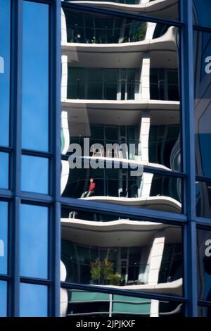 Balcons d'appartement reflétés dans un immeuble de bureaux en verre, Wellington, Île du Nord, Nouvelle-Zélande Banque D'Images