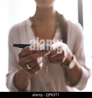 Gérer sa santé. Gros plan d'une femme d'affaires non identifiable qui teste son taux de sucre dans le sang dans un bureau. Banque D'Images