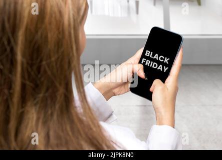 Femme d'affaires affichant le texte du Vendredi fou sur l'écran du téléphone portable. Concept du Vendredi fou Banque D'Images