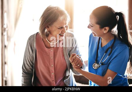 Im ici pour vous aider à chaque étape de la façon. Un soignant aidant un patient âgé dans un foyer de soins infirmiers. Banque D'Images