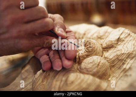 Application des touches de finition. Un artiste sculptant quelque chose en bois. Banque D'Images