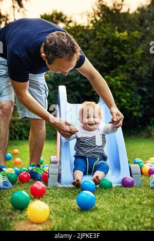 La première fois que j'ai donné un coup de pied à une balle, un adorable petit garçon et son père jouant dans l'arrière-cour. Banque D'Images