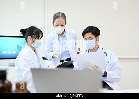 Équipe de scientifiques asiatiques professionnels en robe blanche ayant une réunion de recherche médicale dans le laboratoire. Concept de laboratoire de développement médical. Banque D'Images