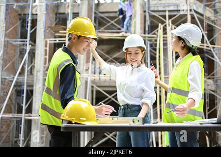 Deux architectes asiatiques professionnels travaillent et inspectent le bâtiment avec un inspecteur de construction ou un ingénieur civil Banque D'Images