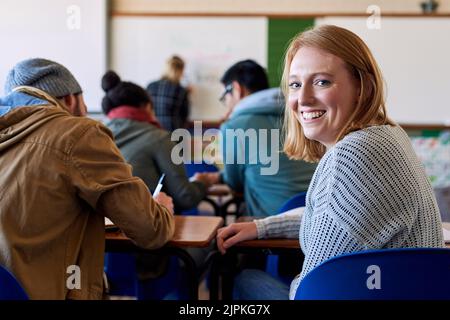 C'est ma conférence préférée. Portrait d'une jeune étudiante de l'université assise en classe pendant une conférence. Banque D'Images