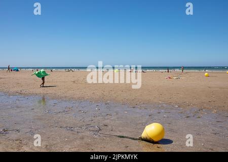 Bronzage à la plage de Benerville-sur-Mer, Normandie, France Banque D'Images