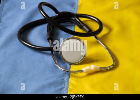 Le stéthoscope se trouve sur le drapeau national de l'Ukraine jaune-bleu, la loi martiale en Ukraine, les soins médicaux dans la guerre Banque D'Images